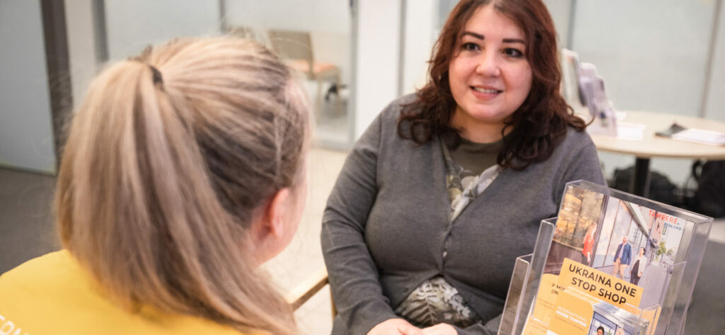 Henkilö neuvoo toista henkilöä pöydän ääressä.