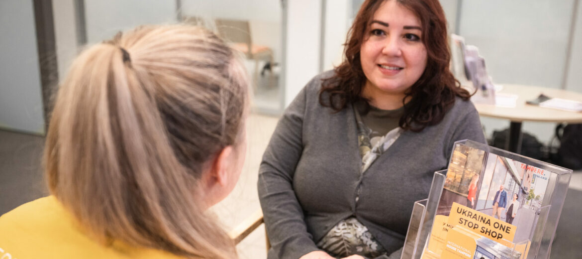 Henkilö neuvoo toista henkilöä pöydän ääressä.